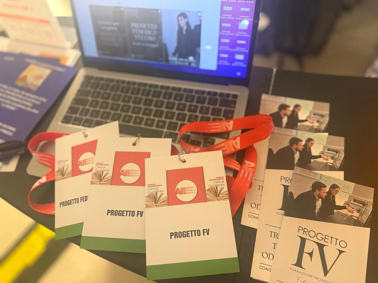 Badge e materiali di Progetto FV preparati per un evento