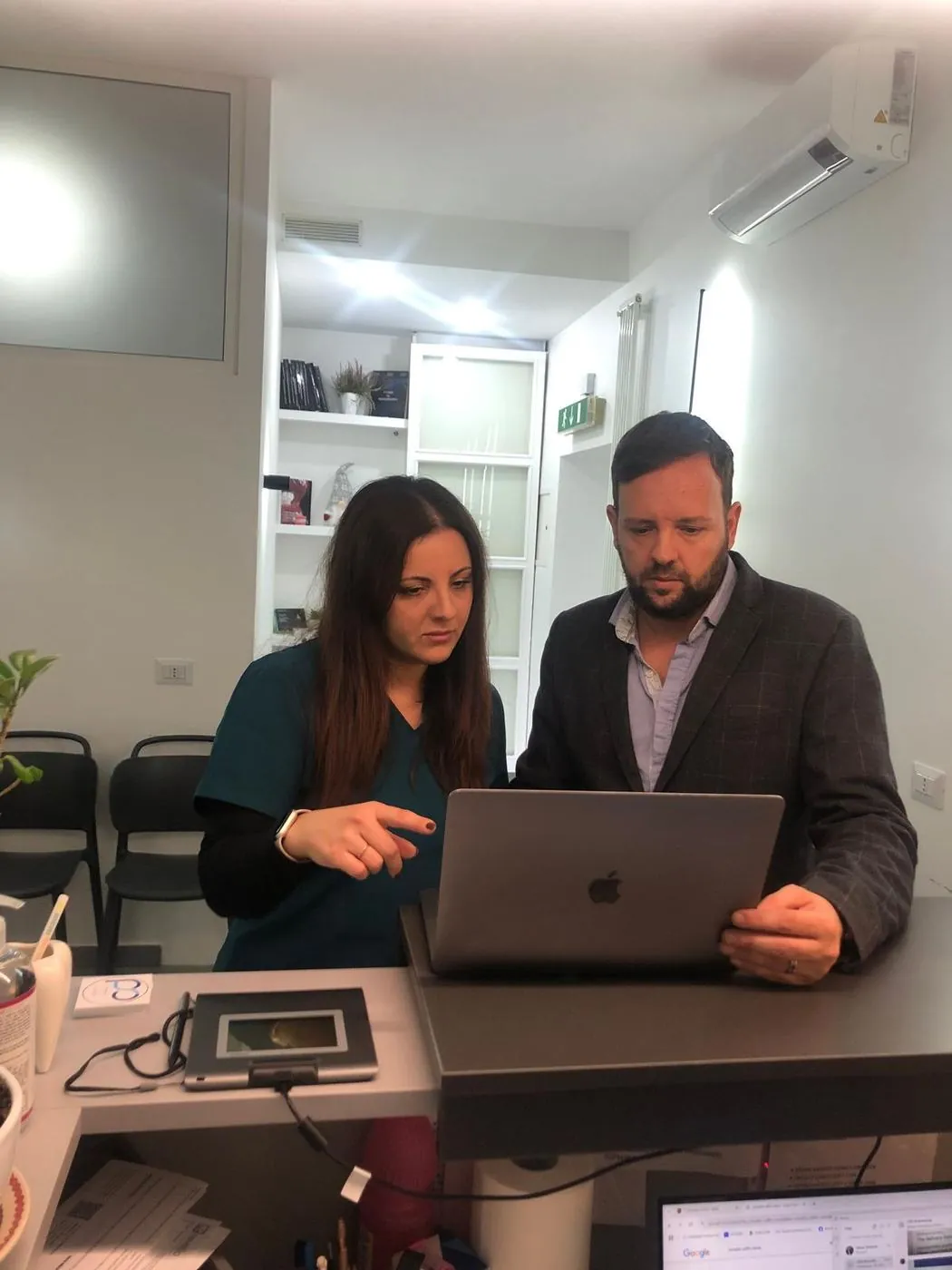 Federico Vecchio in accoglienza, sul computer dello studio insieme a un'assistente